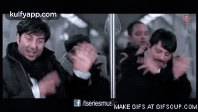 A Group Of Men Standing Next To Each Other On A Train . GIF