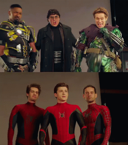 A Group Of Men Standing Next To Each Other With One Of Them Wearing A Spiderman Suit GIF
