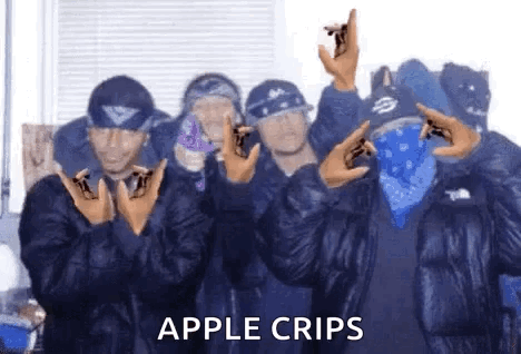A Group Of Men Wearing Blue Bandanas And Jackets Are Standing Next To Each Other And Making A Peace Sign . GIF