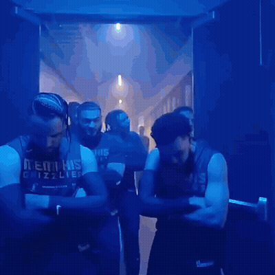 A Group Of Men Wearing Memphis Grizzlies Jerseys Are Standing In A Hallway GIF