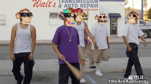 A Group Of Men Wearing Monkey Masks Are Walking Down A Street In Front Of A Walt 'S Auto Repair Store GIF