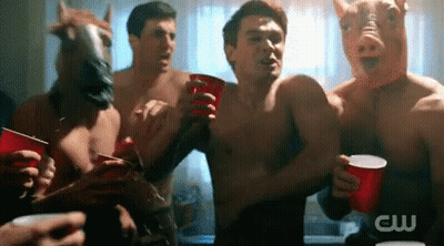 A Group Of Men Wearing Pig Masks And Horse Masks Holding Red Cups GIF