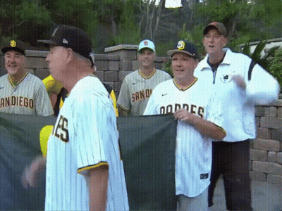 A Group Of Men Wearing San Diego Dodgers Jerseys Are Standing Together GIF