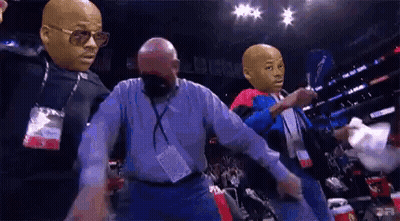 A Group Of Men With Masks On Their Faces Are Dancing In A Boxing Ring . GIF