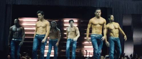 A Group Of Men Without Shirts Are Dancing On A Stage In Front Of A Sign That Says Magic Mike GIF
