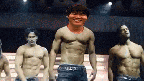 A Group Of Men Without Shirts Are Standing On A Stage . GIF