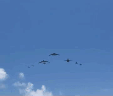 A Group Of Military Planes Are Flying In A Blue Sky . GIF