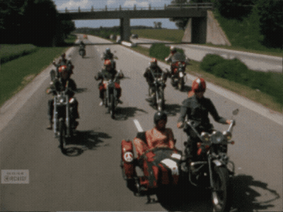A Group Of Motorcycle Riders Are Riding Down A Highway GIF