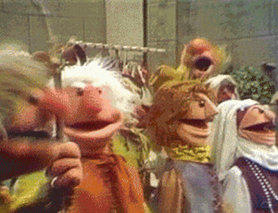 A Group Of Muppets Are Standing In A Room GIF