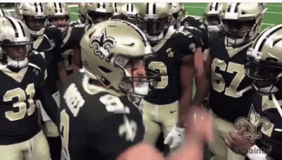 A Group Of New Orleans Saints Football Players Huddled Together GIF
