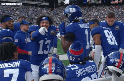 A Group Of New York Giants Players Huddle On The Field GIF