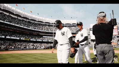 A Group Of New York Yankees Baseball Players Walking On The Field GIF