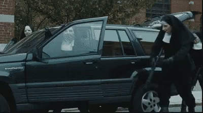 A Group Of Nuns Are Standing In Front Of A Jeep GIF