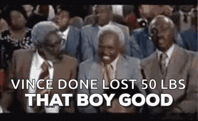 A Group Of Older Men Are Sitting In A Crowd And Laughing . GIF