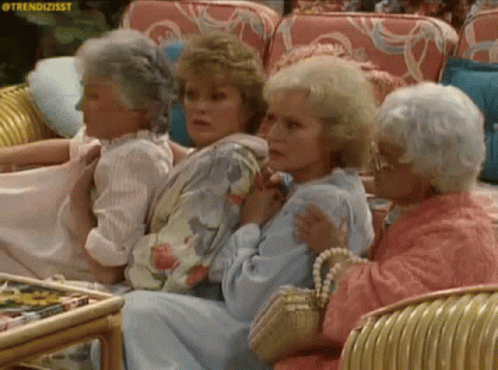A Group Of Older Women Are Sitting In Chairs In A Room . GIF