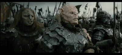 A Group Of Orcs Are Standing Next To Each Other In A Field Holding Spears . GIF