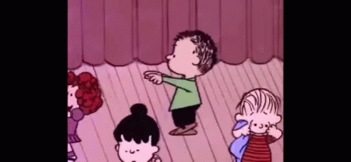A Group Of Peanuts Characters Are Standing On A Stage Dancing . GIF