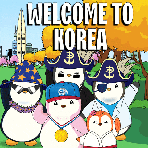 A Group Of Penguins Are Standing In Front Of A Sign That Says " Welcome To Korea " GIF