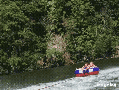 A Group Of People Are Being Towed Down A River By A Boat With Imgplay In The Corner GIF