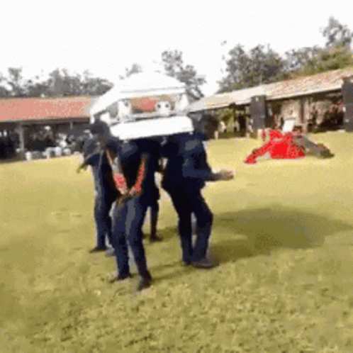 A Group Of People Are Carrying A Coffin On Their Heads GIF