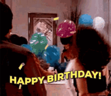 A Group Of People Are Celebrating A Birthday With Balloons And A Woman Is Saying `` Happy Birthday '' . GIF