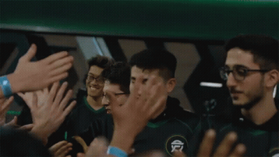 A Group Of People Are Clapping And Applauding A Man In A Green Shirt GIF