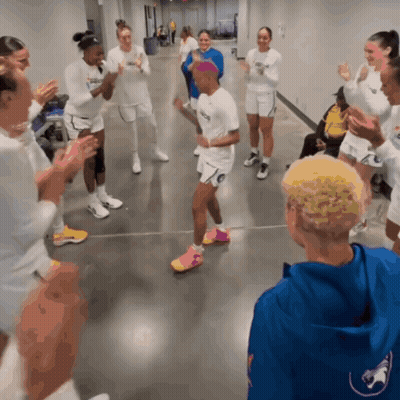 A Group Of People Are Clapping In A Hallway And One Of Them Is Wearing A Shirt That Says ' Nc State ' GIF