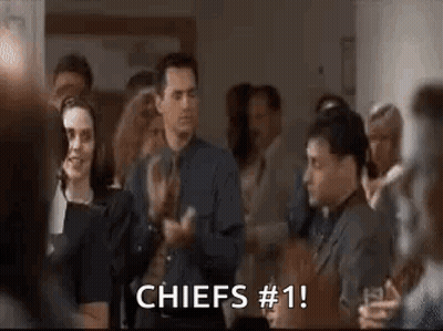 A Group Of People Are Clapping In A Room And A Man Is Saying `` Chiefs # 1 '' . GIF