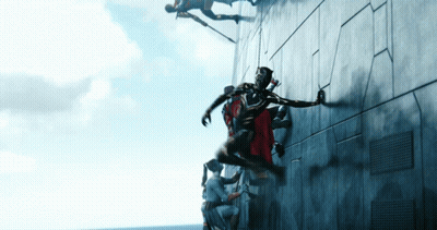 A Group Of People Are Climbing Up A Wall And One Of Them Is Wearing A Red Cape GIF