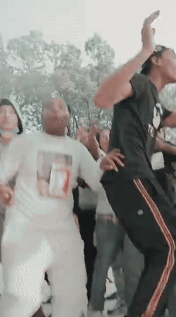 A Group Of People Are Dancing And One Of Them Is Wearing A White Shirt With A Picture Of A Girl On It GIF