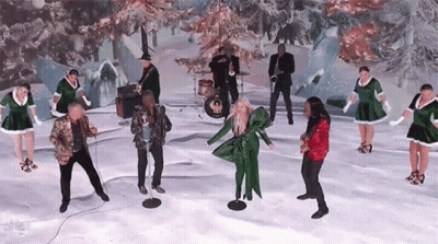 A Group Of People Are Dancing And Singing In The Snow . GIF