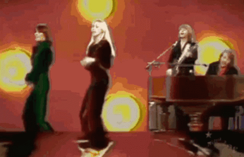 A Group Of People Are Dancing And Singing On A Stage GIF