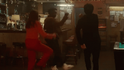 A Group Of People Are Dancing In A Bar While A Woman Stands On A Bar Stool . GIF