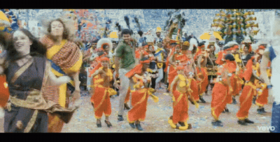 A Group Of People Are Dancing In A Colorful Parade . GIF