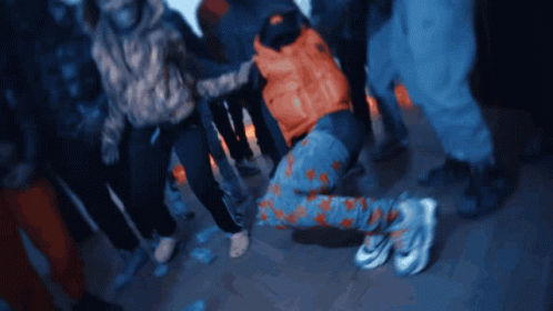 A Group Of People Are Dancing In A Dark Room GIF