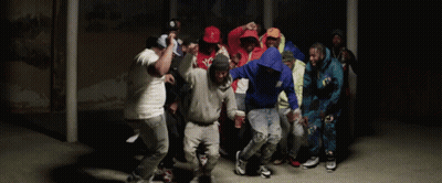 A Group Of People Are Dancing In A Dark Room And One Of Them Is Wearing A Hoodie That Says ' A ' GIF