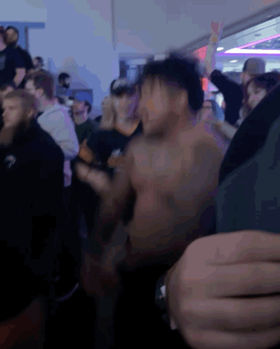 A Group Of People Are Dancing In A Dark Room GIF