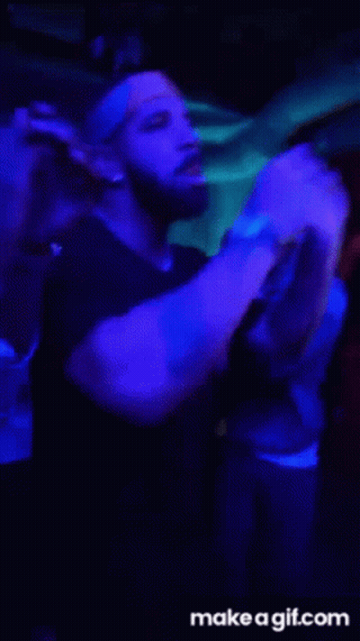 A Group Of People Are Dancing In A Dark Room With Blue Lights .. GIF