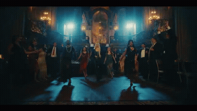 A Group Of People Are Dancing In A Dark Room With Candles . GIF