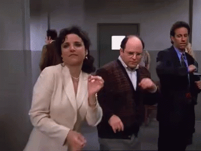 A Group Of People Are Dancing In A Hallway While A Woman Looks On . GIF