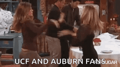A Group Of People Are Dancing In A Kitchen With The Words `` Ucf And Auburn Fans Sugar '' Written Above Them . GIF