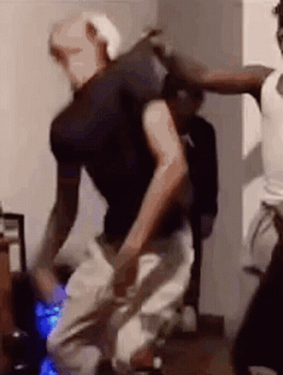 A Group Of People Are Dancing In A Living Room . GIF