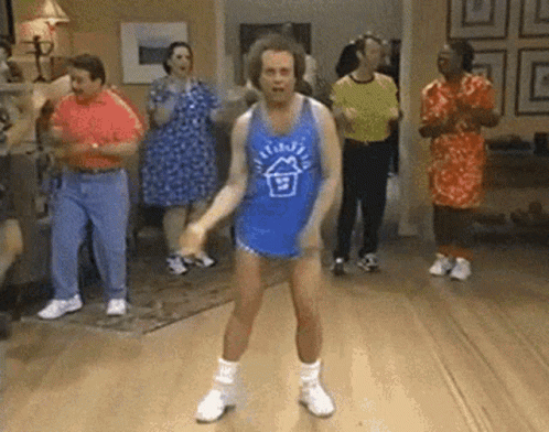 A Group Of People Are Dancing In A Living Room . GIF