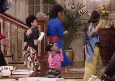 A Group Of People Are Dancing In A Living Room With Stairs . GIF