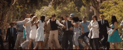 A Group Of People Are Dancing In A Park GIF