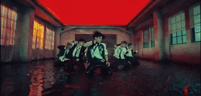 A Group Of People Are Dancing In A Room With A Red Ceiling . GIF