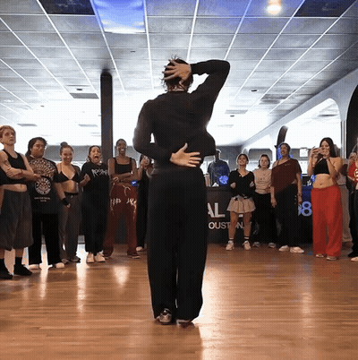 A Group Of People Are Dancing In A Room With A Sign That Says Al GIF