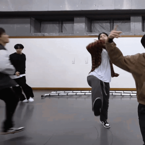 A Group Of People Are Dancing In A Room With A White Wall In The Background GIF