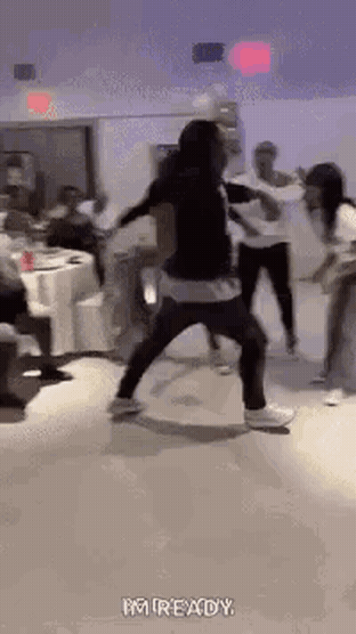 A Group Of People Are Dancing In A Room With Tables And Chairs . GIF