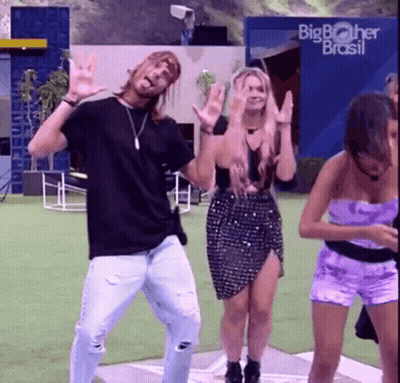 A Group Of People Are Dancing In Front Of A Big Brother Brasil Building GIF